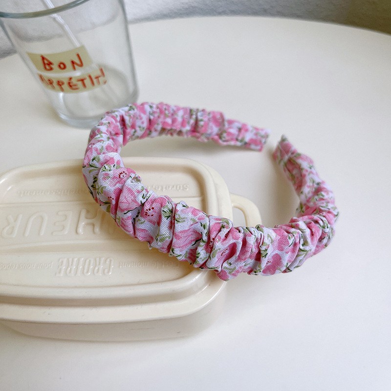 (imagen de) Diadema acolchada rosa con tejido fruncido y estampado floral