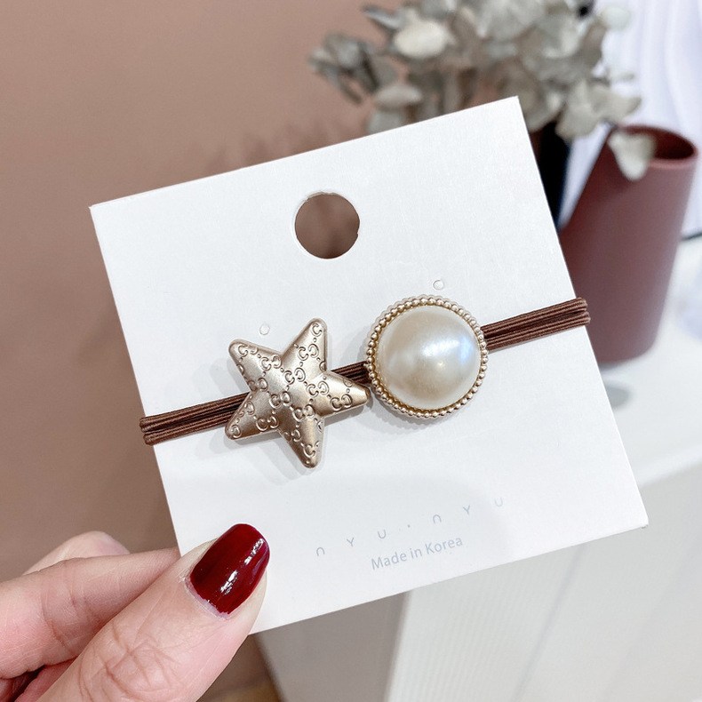 (imagen de) Goma para cabello marrón con estrella metálica y perla