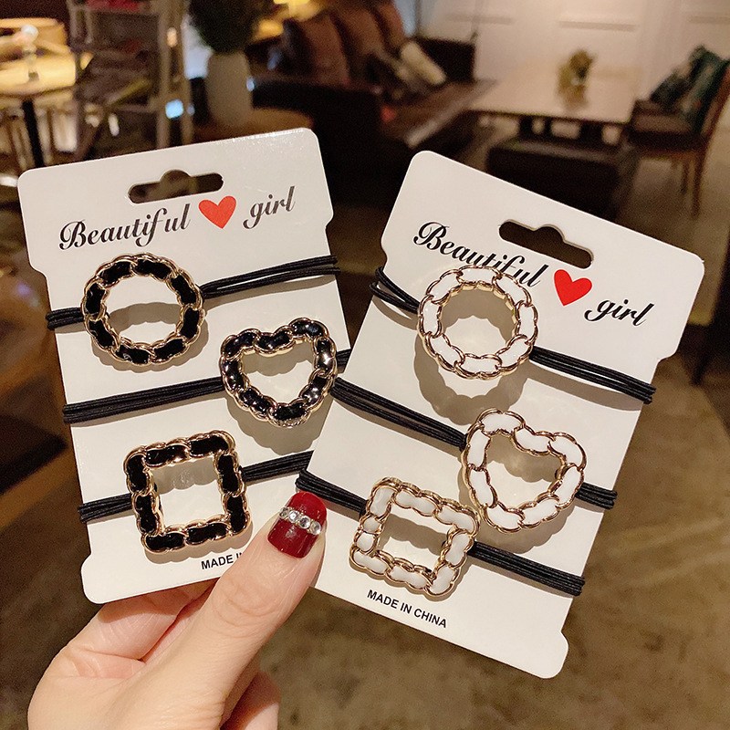 (imagen de) Set de 3 gomas elásticas con charms de cadena y acabado dorado